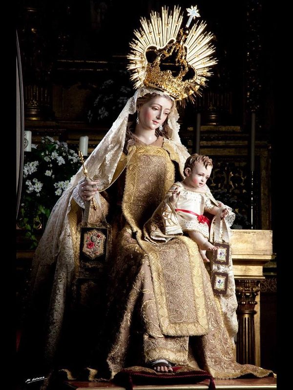 Virgen del Carmen en trono con manto marrón mostrando el escapulario al Niño Jesús