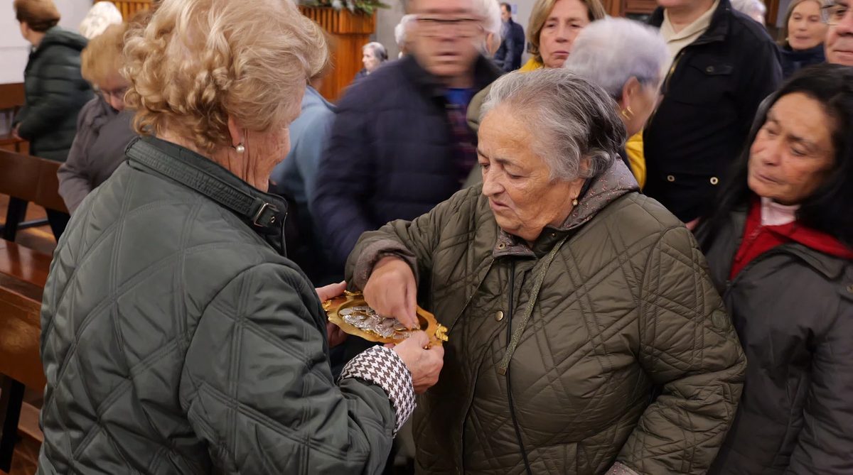 Fieles recibiendo y venerando la Medalla Milagrosa en una iglesia